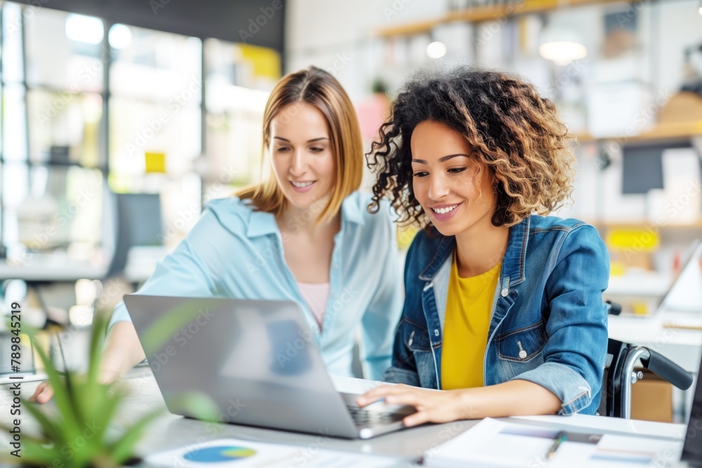 two diverse women engaged in work on a laptop in a vibrant office setting. two diverse women engaged in work on a laptop in a vibrant office setting.
