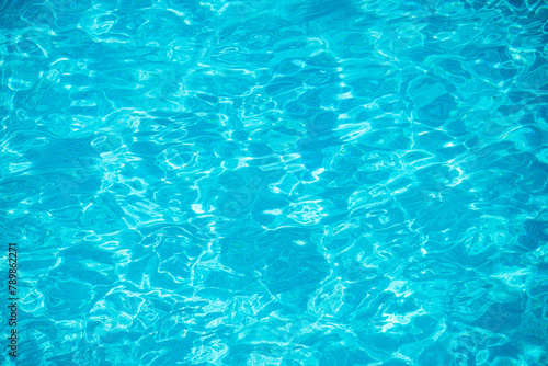 Swimming pool bottom caustics ripple and flow with waves background. Summer background. Texture of water surface. Overhead view.