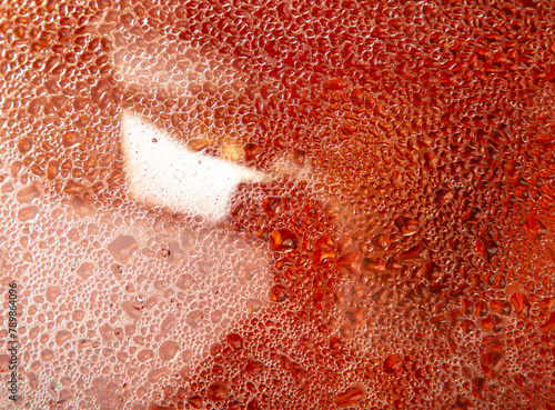Drops of water on glass with a red tint. Backgroun