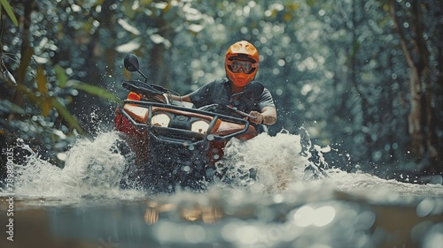 Asian guy driving a quad in the forest by himself and having a good time. In the thick woodland, drive through the river.