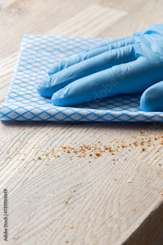 Cleaning wiping wood countertop worktop with a disposable cloth. Housework chores concept