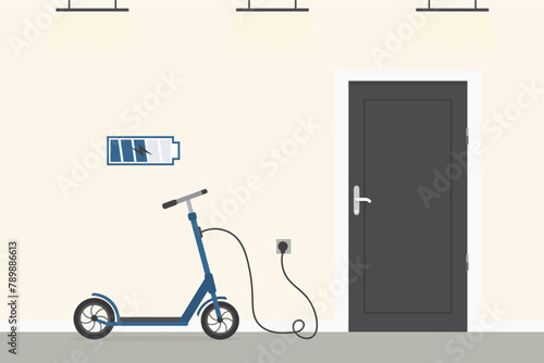 Ecological city transport, modern technology. Electric scooter charged at home from electrical mains. Electric wire is plugged into the outlet. Kick scooter standing in hall.