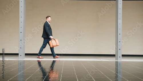 Side view of business people holding suitcase and walking to workplace along the street in urban city. Professional project manager going to meeting while wearing formal suit walk at outdoor. Urbane.