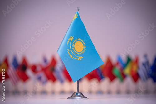 a small flag of kazakhstan is sitting in front of a row of other flags