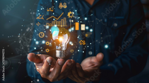 Businessman holding creative light bulb with growth graph, analytics icons. Utilizing analytics technology to develop new strategies and insights that enhance successful performance in global business