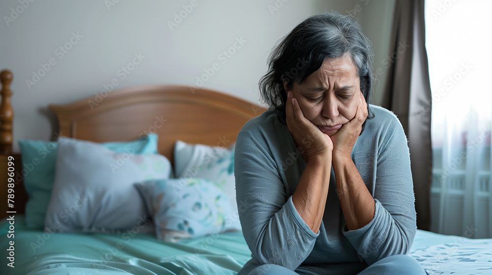 copy space, stockphoto, elderly hispanic woman sitting on bed, having a depression. Mental health of elderly people, senior woman sitting on the bed, feeling lonely. Mental health problems, depression copy space, stockphoto, elderly hispanic woman sitting on bed, having a depression. Mental health of elderly people, senior woman sitting on the bed, feeling lonely. Mental health problems, depression