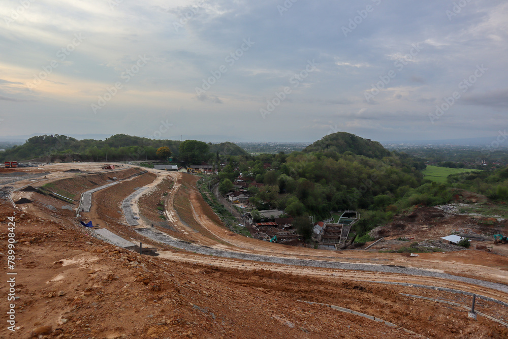 Yogyakarta, October 30, 2021: The process of arranging the Piyungan landfill using heavy equipment and the sight of cows around the landfill.