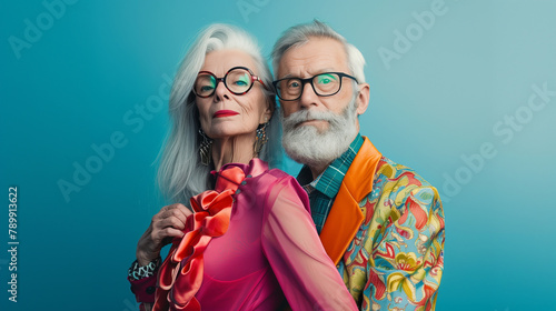 copy space, stockphoto, high resolution, senior Caucasian couple in vivid extravagant outfits and glasses with gray hair, professional photo shoot. elderly couple, man and woman,extravagant vibrant co