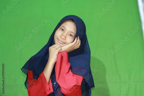 Beautiful Asian woman posing spoiled with a blue headscarf and red shirt. Hijab-wearing teenager from Indonesia