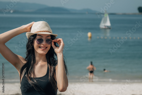portrait of tourist with hat and sunglasses on the beach © tetxu