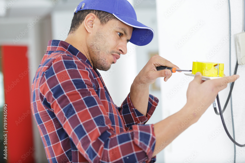electrician working at plug socket on a wall electrician working at plug socket on a wall