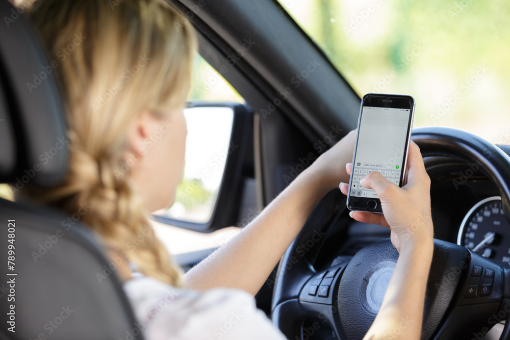 a woman texting while driving a woman texting while driving