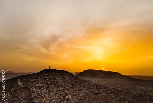 Beautiful aerial sunset image over Volcan Calderon Hondo volcanic crater silhouetted against the setting sun and skyscape near Corralejo, Fuerteventura, Canary Islands, Spain