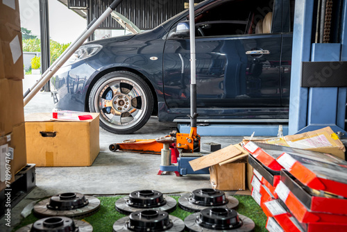 Car mechanic or serviceman disassembly and checking a disc brake and asbestos brake pads for fix and repair problem at car garage or repair shop