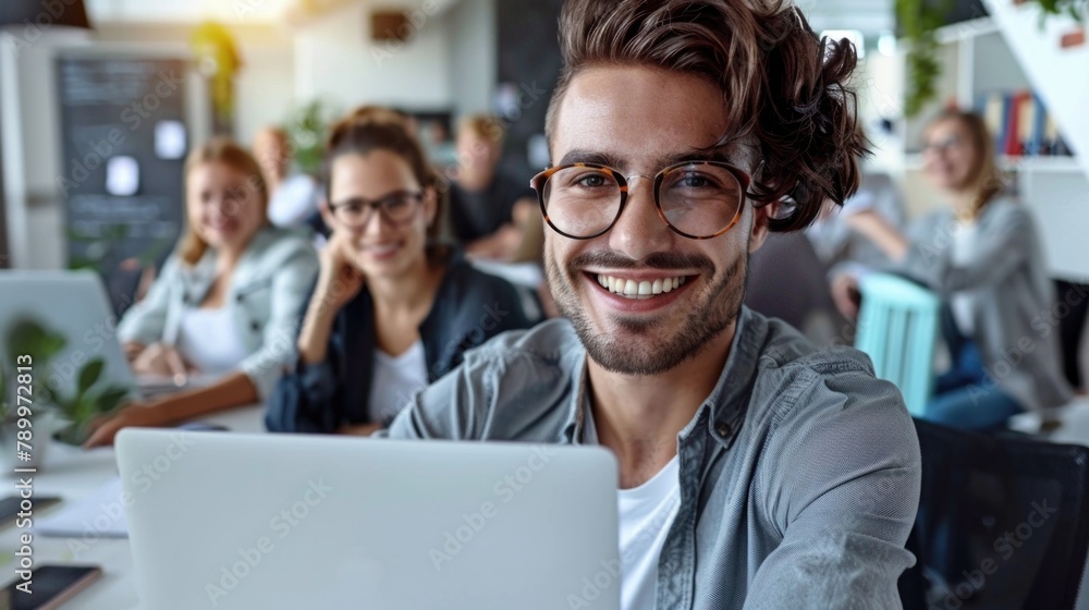 A diverse group of individuals sitting around a laptop computer in an office setting, engaged in a collaborative discussion or project A diverse group of individuals sitting around a laptop computer in an office setting, engaged in a collaborative discussion or project