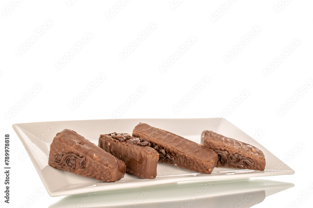 A few pieces of chocolate waffle cake on a white ceramic plate macro, isolated on a white background. A few pieces of chocolate waffle cake on a white ceramic plate macro, isolated on a white background.