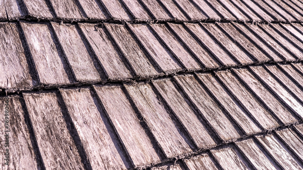 Close up of wood texture and background. Natural cedar shingle siding. Rough bumpy wood shingle cladding, row of wooden material of small shingle wall facade Close up of wood texture and background. Natural cedar shingle siding. Rough bumpy wood shingle cladding, row of wooden material of small shingle wall facade