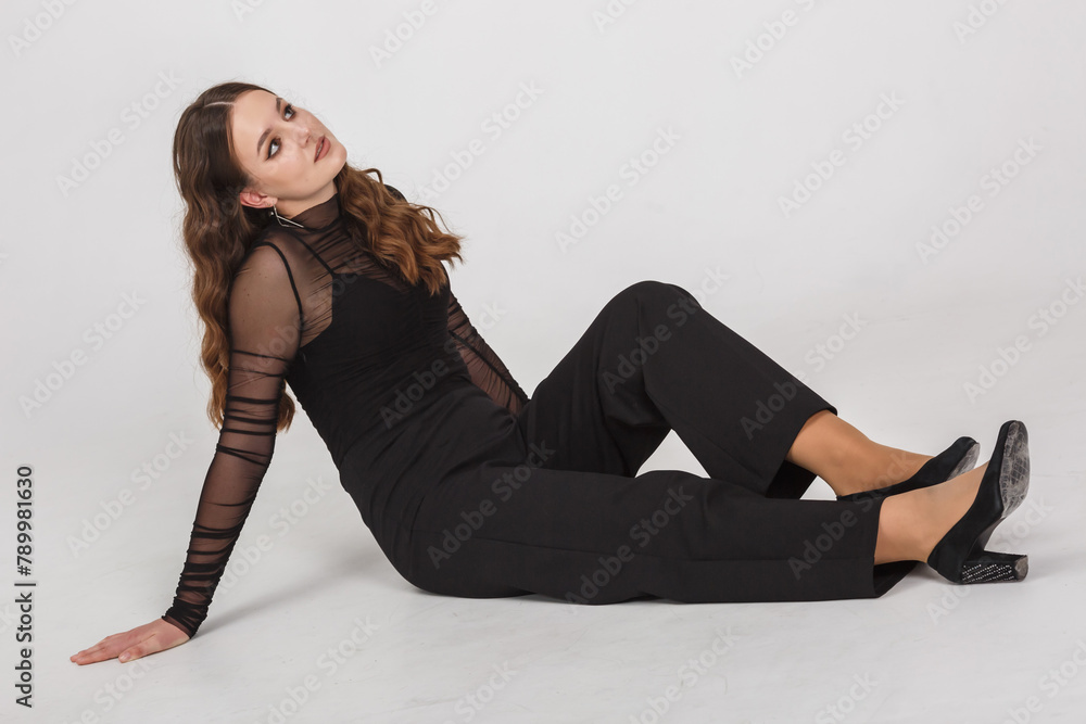 girl model in black shirt trousers posing relaxed in studio on white background girl model in black shirt trousers posing relaxed in studio on white background