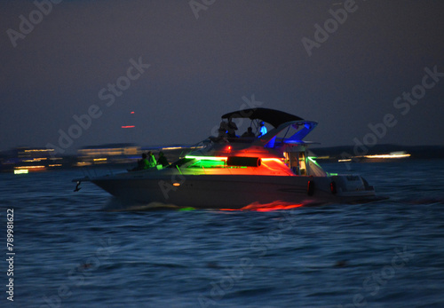 Motorówka podświetlona kolorowymi lampkami płynąca na morzu karaibskim po zachodzie słońca