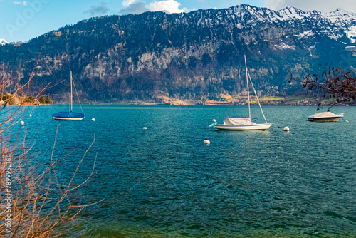 Alpine view on a cloudy spring day with boats on Lake Thunersee near Merligen, Sigriswil, Bern, Switzerland photo