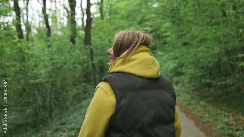 Portrait of cheerful happy lady walks by trail in spring, enjoying time in forest. Female hiker relax in nature for mental health, wellness and breathing, forest trees and fresh air. Portrait of cheerful happy lady walks by trail in spring, enjoying time in forest. Female hiker relax in nature for mental health, wellness and breathing, forest trees and fresh air.
