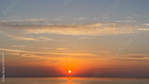 A bright sunset over the sea. The sun is setting over the horizon