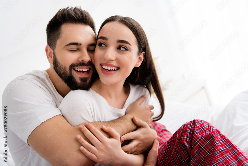 Photo of positive cheerful couple guy love warmth cuddle his laughing wife in white house indoors Photo of positive cheerful couple guy love warmth cuddle his laughing wife in white house indoors
