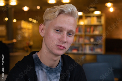 A young blond guy studies in a co-working space where you can get a lot of knowledge