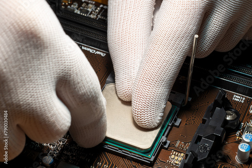 Man hands in gloves replacing processor on the computer motherboard