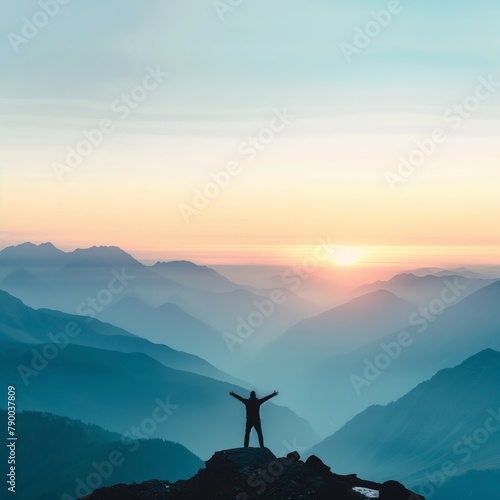 Person with arms raised standing on a mountain peak during a colorful sunrise.
