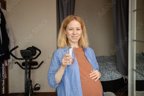 Pregnant woman drinks water, hydration for motherhood, nourishing the pregnancy, caring for both mom and baby