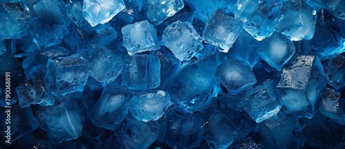 Closeup of blue ice cubes with water droplets on black surface, refreshing and cool concept for summer drinks and cocktails photo