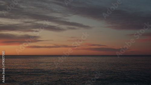 Sunset on pebble beach with sea waves of mediterranean sea