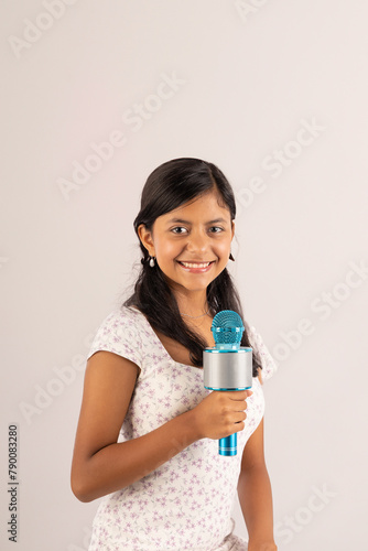 A girl is holding a microphone and smiling