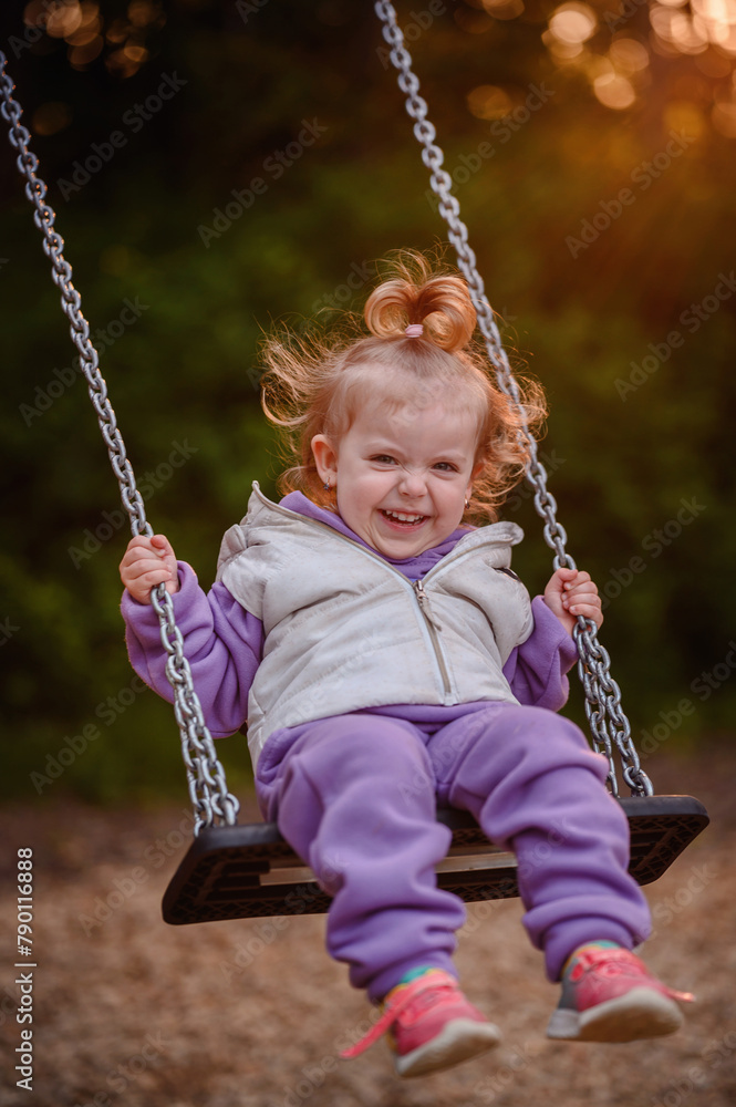 A toddler exudes sheer joy on a swing, her delightful laughter and energetic spirit catching the warm evening sunlight through the trees A toddler exudes sheer joy on a swing, her delightful laughter and energetic spirit catching the warm evening sunlight through the trees