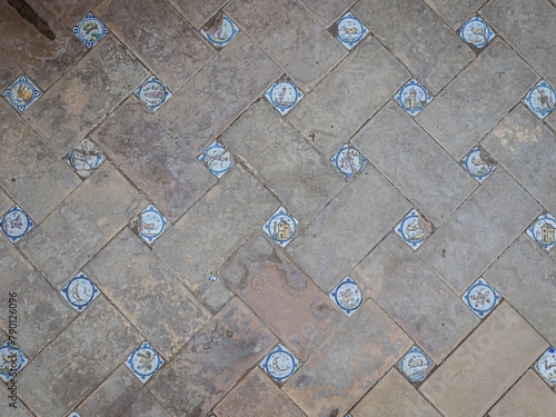 Medieval terracotta floor in Seville, Andalusia, with Spanish tiles picturing animals and houses