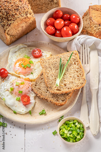 American breakfast with fried eggs, bread and chive.