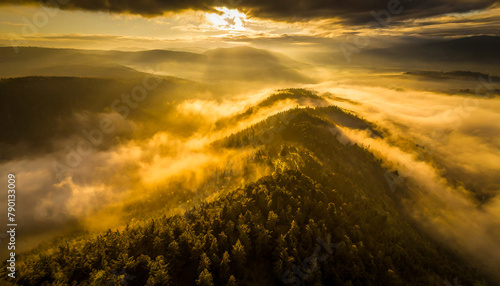 Ariel view of tree covered mountains with morning mist at sunrise