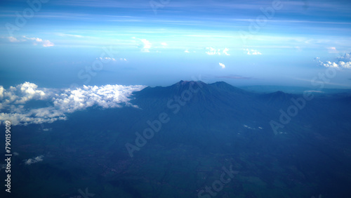 Aerial view of Bali island from the airplane window. The earth panorama with Bali island view , mountain, blue sky and white cloud background. Natural nature landscape background.