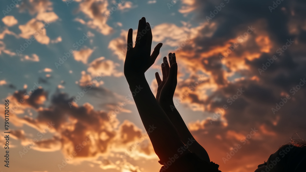 Silhouette of hands reaching upwards towards a dramatic sunset sky with clouds. Hope and aspiration concept. Design for motivational poster, spiritual event flyer, and self-growth workshop banner.