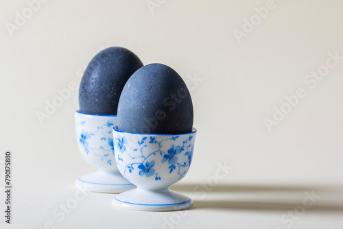 Eggs colored with wine in an egg cup on a light background. Easter concept.