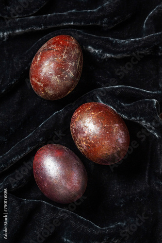 Obraz na płótnie Eggs stained with wine and covered with mother-of-pearl on a dark velvet background. Easter concept. w salonie