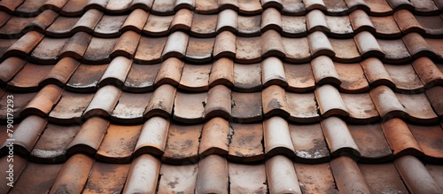 A close up of a roof covered with numerous brown tiles