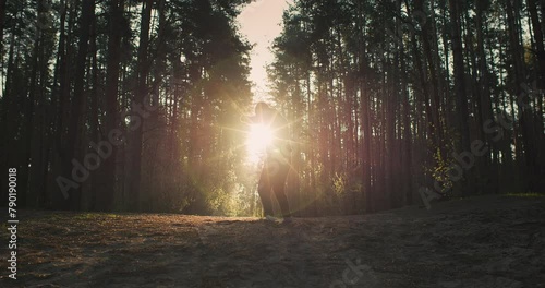 Wide shot of young man athlete training in the forest. Shadow boxing and running on sunrise in nature photo