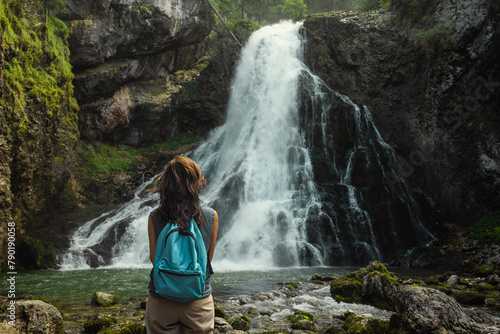 A woman standing at the Gollinger Waterfall in Torren, a district of Golling.