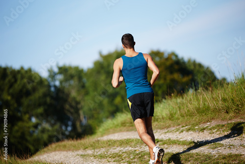 Man, running and path in nature for fitness, health and race in outdoor for workout or exercise. Male athlete, strong and cardio with challenge, adventure and training for sports or marathon