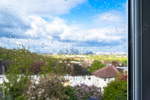 Rain drops on a window glass against a cloudy sky in Greenwich, London