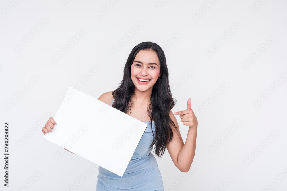 Young woman in baby blue dress enthusiastically pointing to a blank sign, isolated on white Young woman in baby blue dress enthusiastically pointing to a blank sign, isolated on white