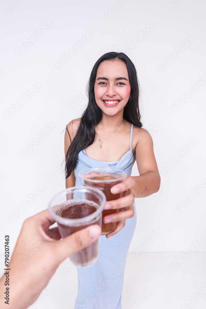 Young woman in a baby blue dress making a toast with iced tea Young woman in a baby blue dress making a toast with iced tea