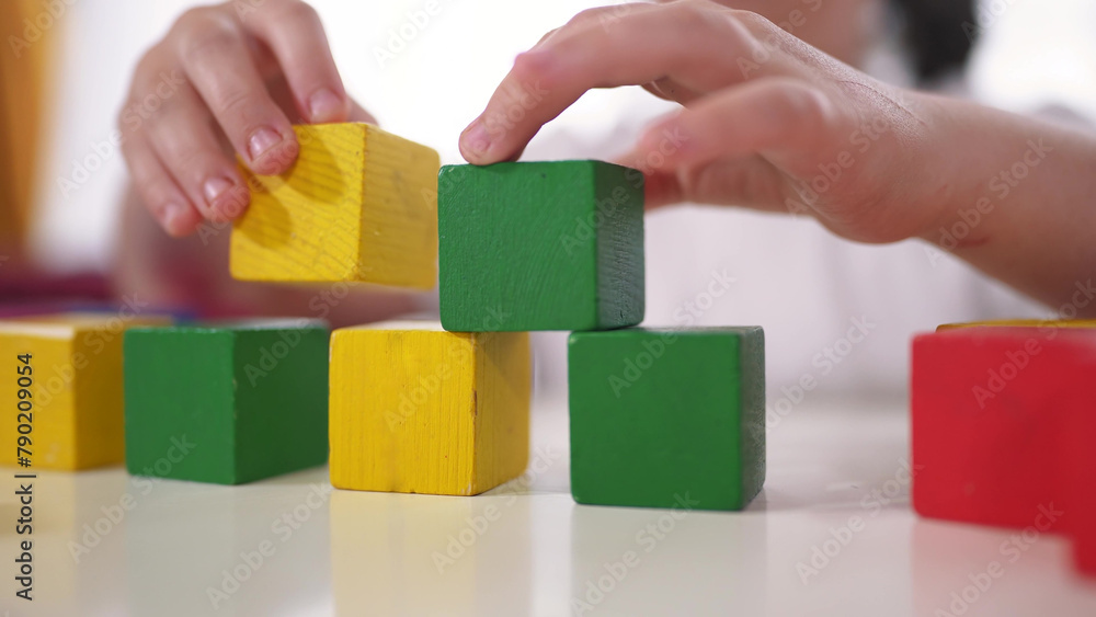 child playing cubes close-up. education a children development of fine motor skills concept. child close-up hands plays with blocks develops fine motor skills. kid plays lifestyle with cubes child playing cubes close-up. education a children development of fine motor skills concept. child close-up hands plays with blocks develops fine motor skills. kid plays lifestyle with cubes